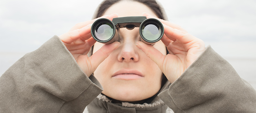 Woman Looking Through Binoculars at Threats