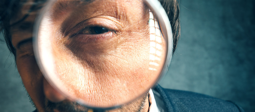 Developer Examining Vulnerability Data with Magnifying Glass