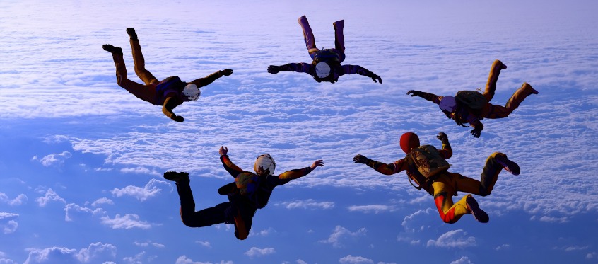 Skydivers Freefalling Against Blue Sky